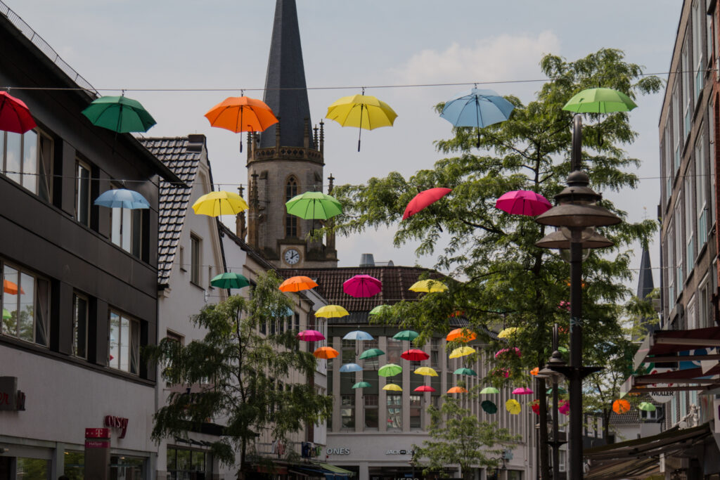 Bunte Regenschirme hänger über der Mittleren Berliner Straße