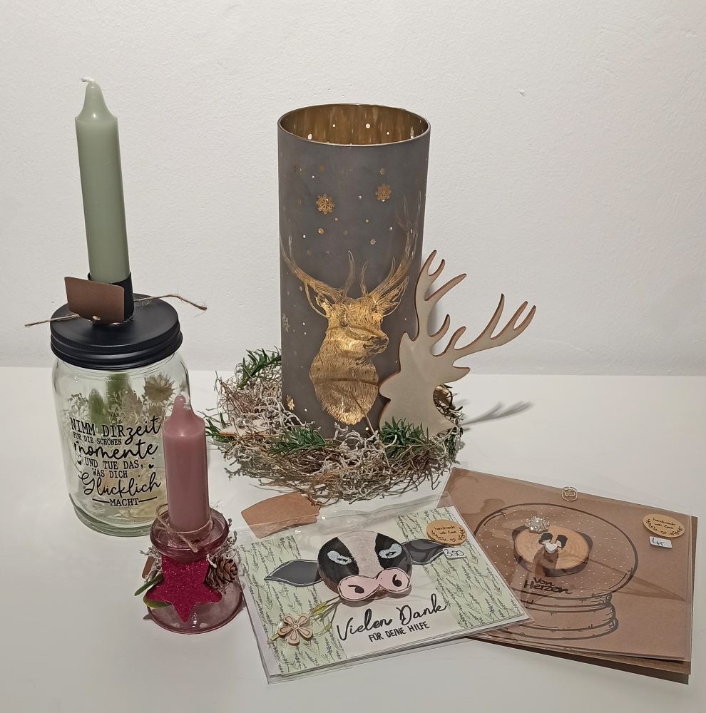 Verschiedene Dekoartikel mit Trockenblumen, Kerzenständer, und Grußkarten, arrangiert vor einem weißen Hintergrund